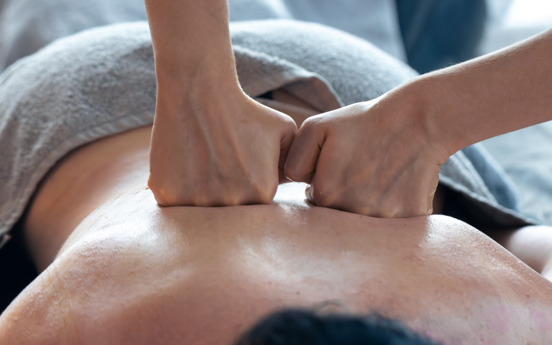 Deep tissue massage therapist working on chronic muscle tension and knots at Uniq Massage in McKinney, TX